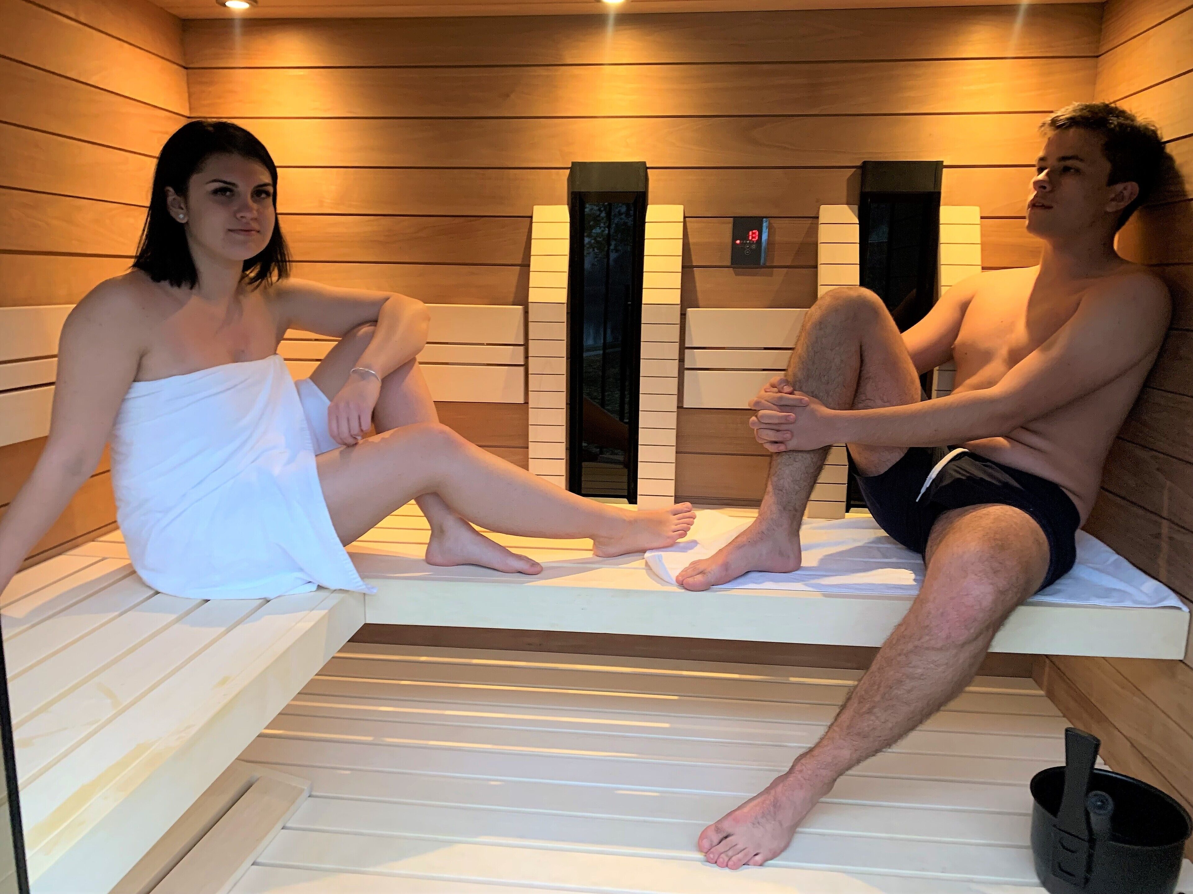 A sauna with wooden benches and a digital control panel.