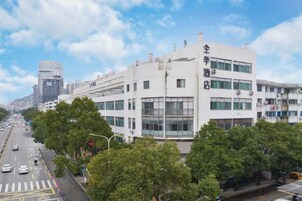 Un edificio de varios pisos con un diseño arquitectónico moderno, que presenta grandes ventanales y un techo plano.