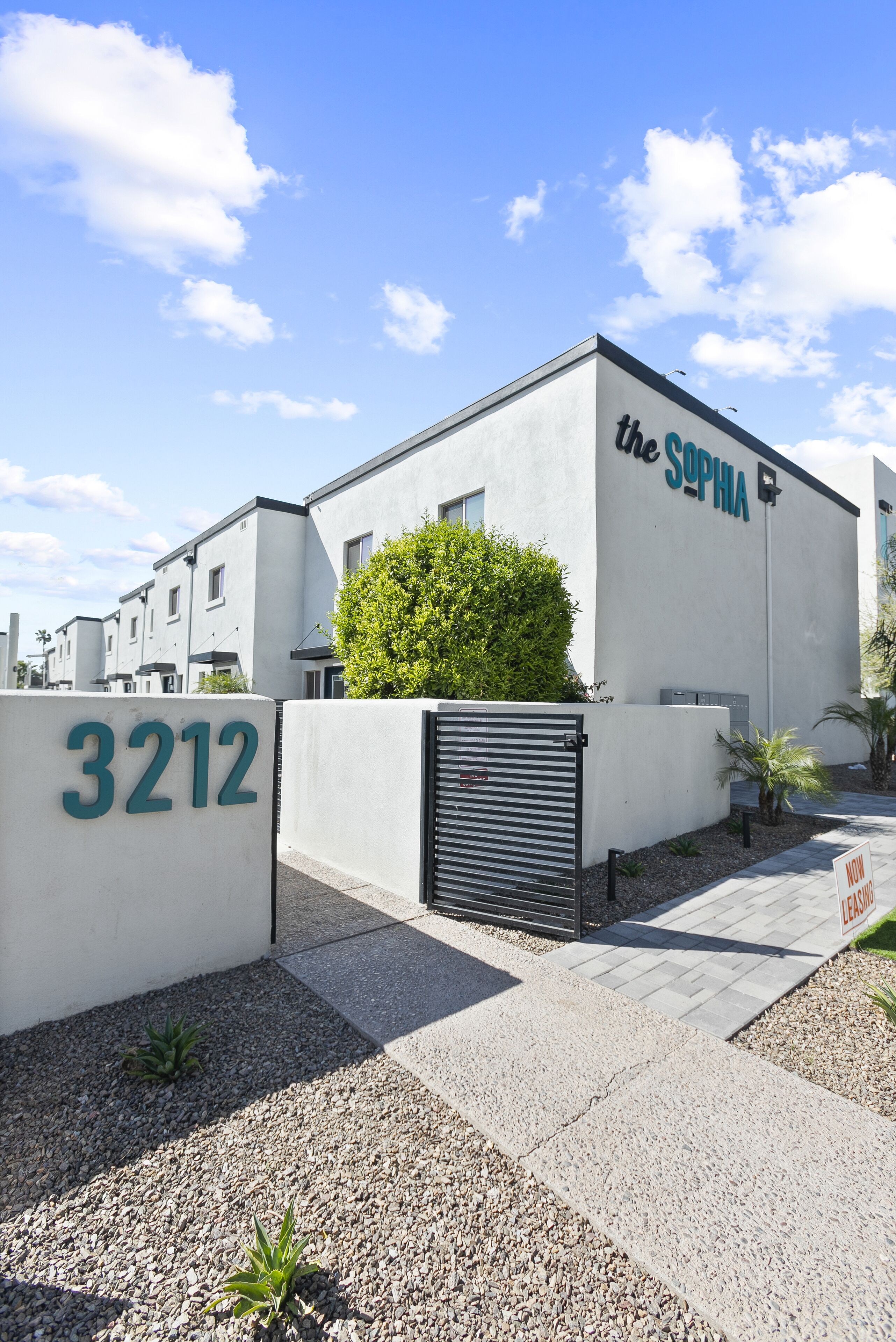 A modern building with the name "the SOPHIA" on the side, a gated entrance, and a number "3212" on a sign.