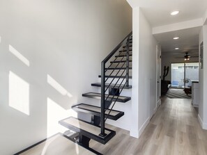 A modern staircase with a minimalist design, leading to a well-lit interior space. - Sophia (Scottsdale)