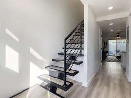 Una escalera moderna de diseño minimalista que conduce a un espacio interior bien iluminado.