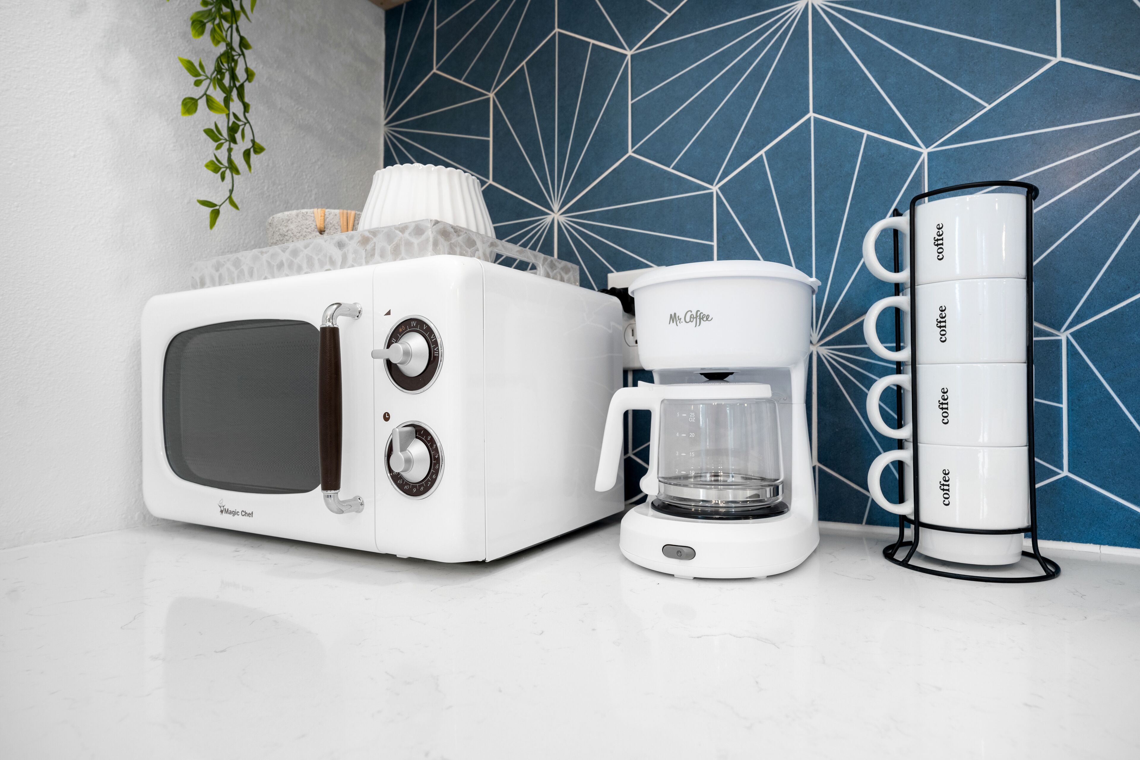 Une cuisine équipée d’une machine à café, d’un grille-pain et d’un porte-tasses.