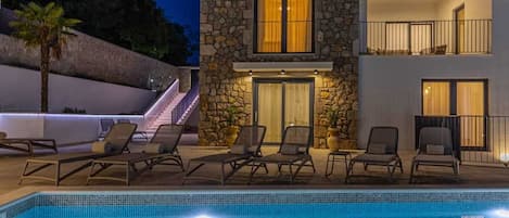 Enjoy a refreshing swim in the pool surrounded by lounge chairs.
