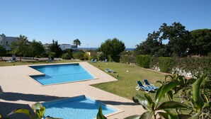 A swimming pool with lounge chairs and a view of the sea. - Holiday house with big roof terrace pool and sea view (Porches,Lagoa)
