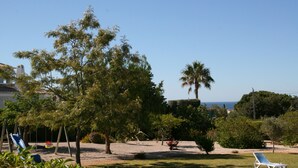 A backyard with a swing set, a hammock, and a lawn chair. - Holiday house with big roof terrace pool and sea view (Porches,Lagoa)
