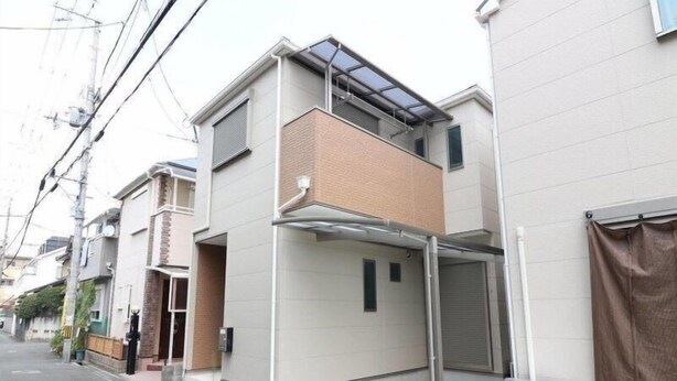 A modern residential building with a flat roof, a balcony, and a garage door. - HG Cozy Hotel (Neyagawa)