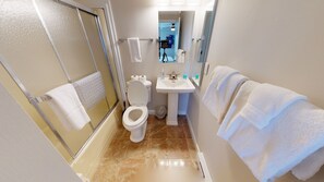 A bathroom with a toilet, sink, and shower. There are towels hanging on the wall and a mirror above the sink. - Ski in/Ski out Mountain Retreat! With abundant activities for all seasons! (Snowshoe)