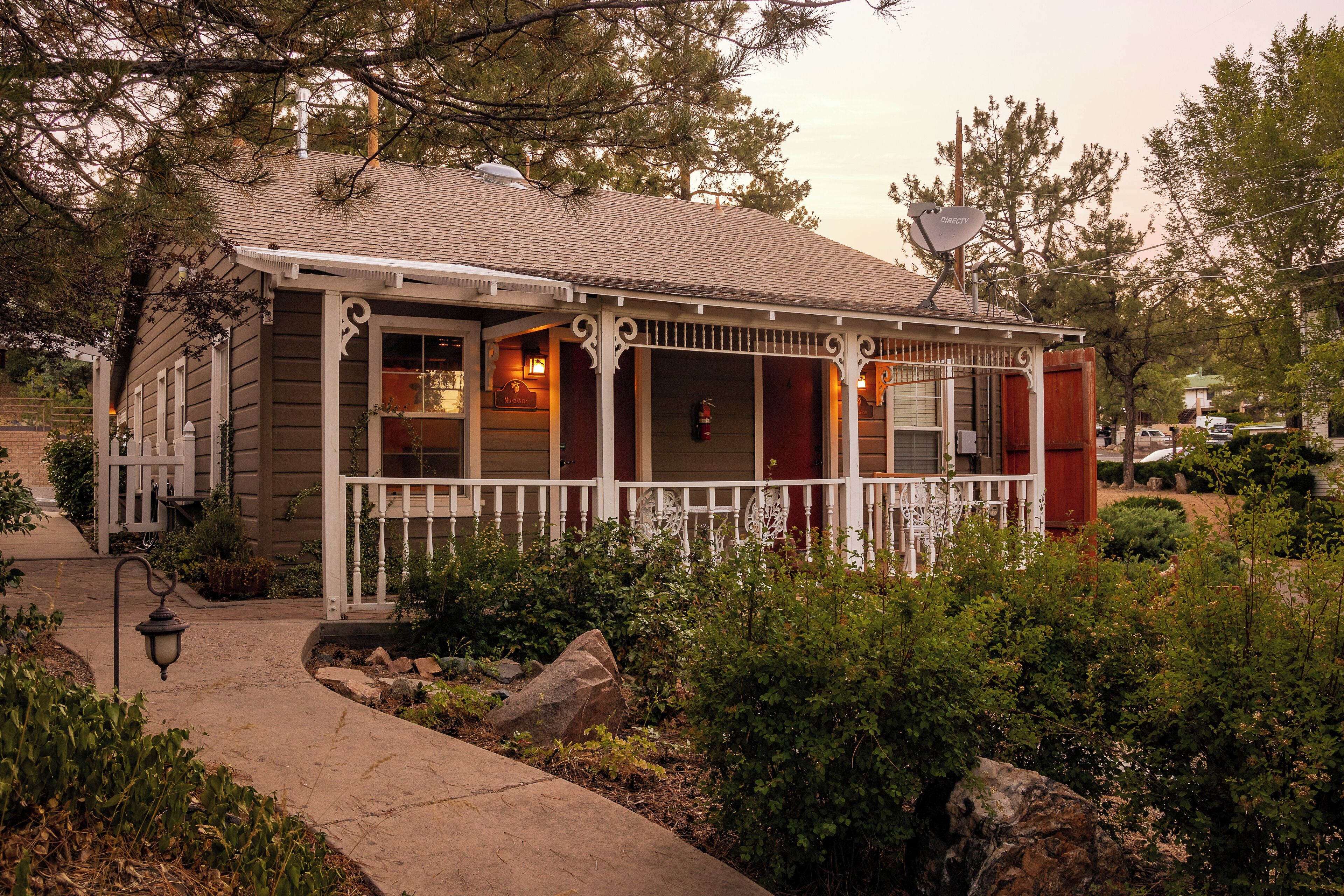 A two-story house with a porch, a satellite dish, and a fire extinguisher.