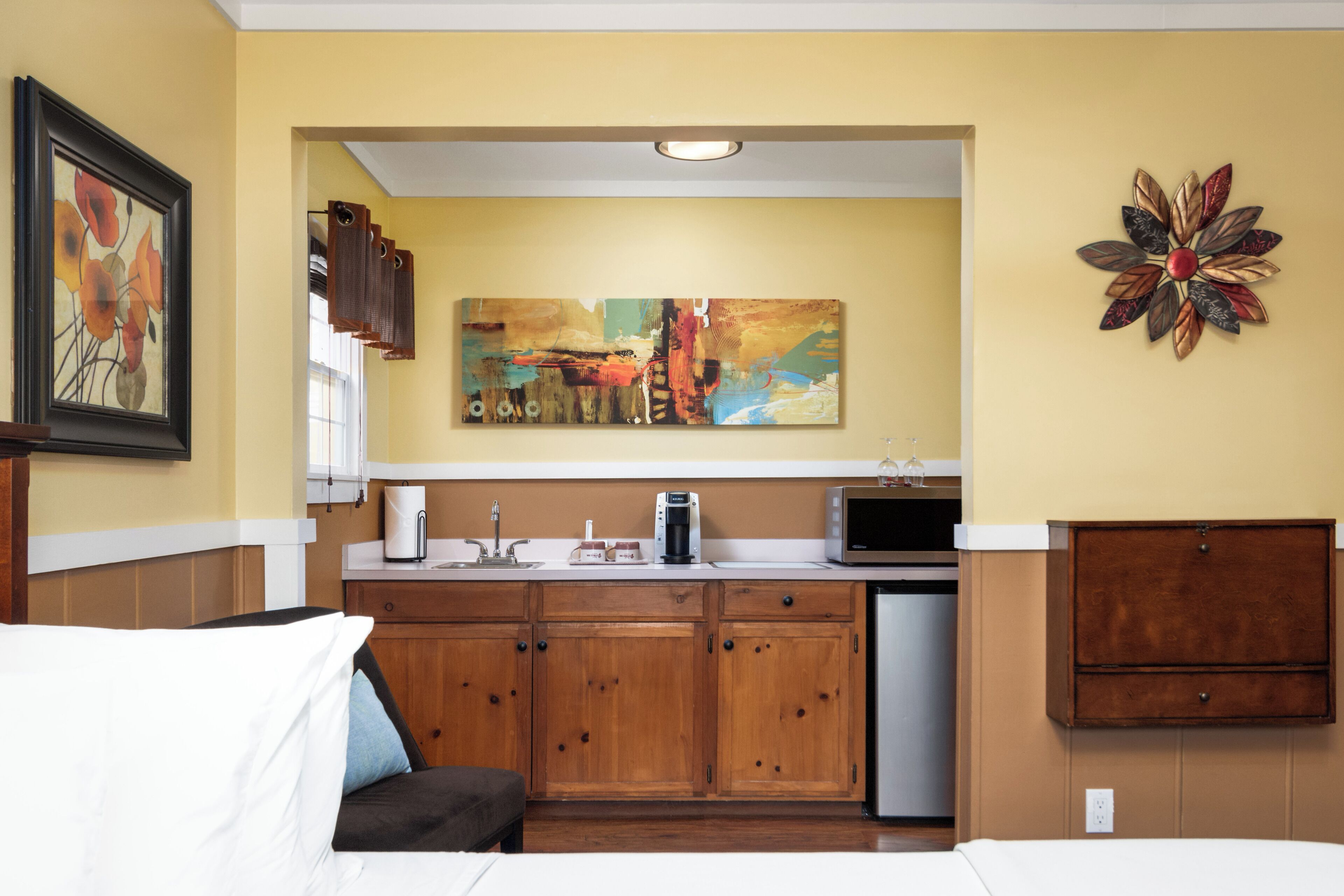 A compact kitchen with wooden cabinets, a microwave, and a coffee maker.