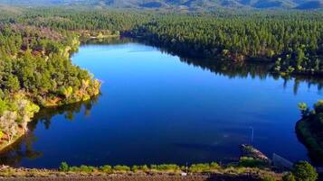 Suuri järvi, jonka ympärillä on tiheää metsää ja kukkuloita.
