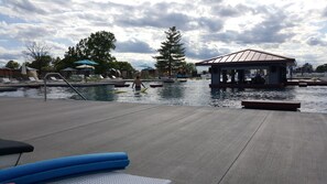 Ein Poolbereich mit Liegestühlen, einem kleinen Pavillon und einem Rettungsschwimmerstand.