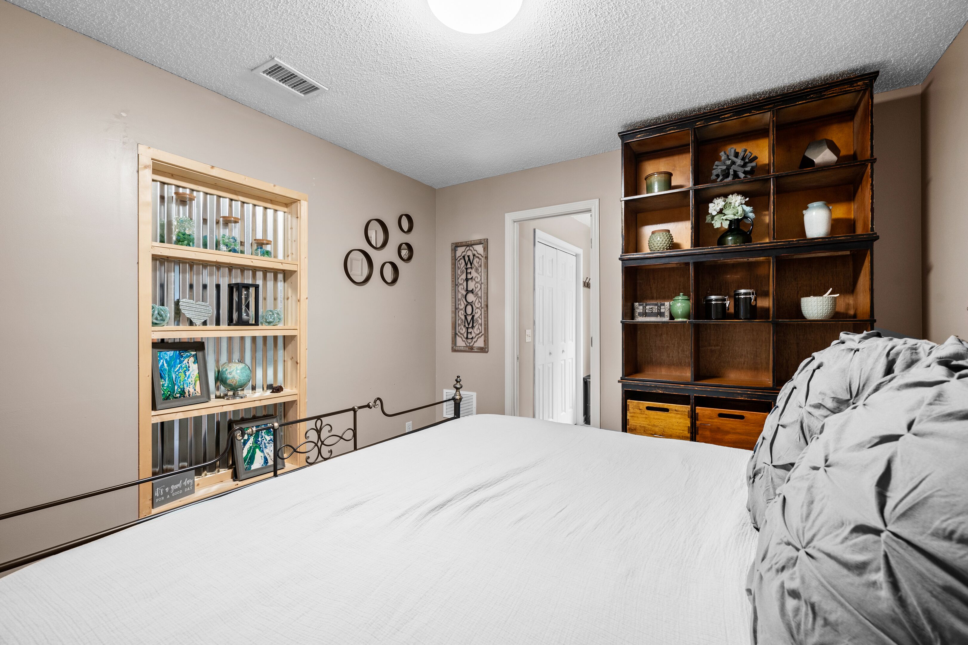 Un dormitorio con una cama, una estantería de madera y una pared decorada con adornos circulares.