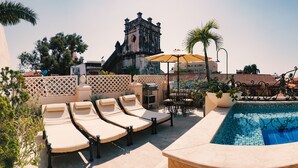 A rooftop pool area with lounge chairs, a small table, and a decorative fence. - COLONIAL HOUSE WITH CONTEMPORARY TOUCHES 7 ROOMS WITH TERRACE AND 2 SMALL POOLS (cartagena)