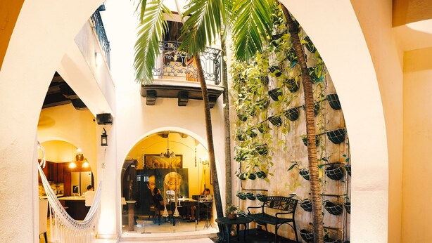 A pool area with a hammock, a dining area, and a staircase leading to an upper level. - COLONIAL HOUSE WITH CONTEMPORARY TOUCHES 7 ROOMS WITH TERRACE AND 2 SMALL POOLS (cartagena)