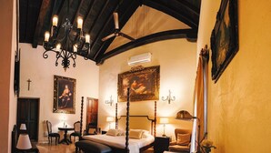 A bedroom with a four-poster bed, a chandelier, a ceiling fan, and two paintings on the wall. - COLONIAL HOUSE WITH CONTEMPORARY TOUCHES 7 ROOMS WITH TERRACE AND 2 SMALL POOLS (cartagena)