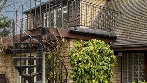 A house with a stone facade, a wooden staircase, and a large ivy-covered wall. - Sandford Meadow Guest House (Oxford)