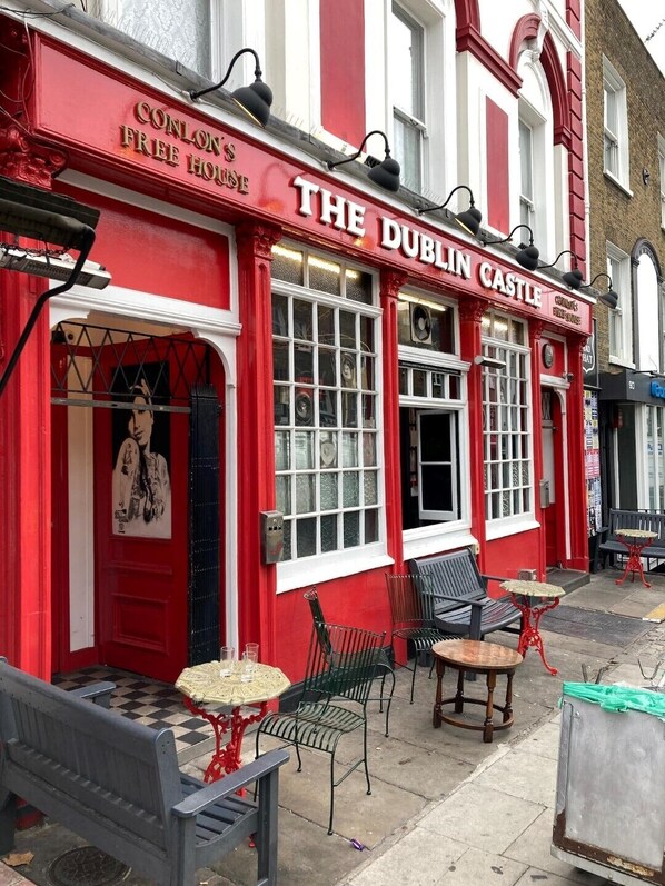 The Dublin Castle, a red and white building with outdoor seating and a vintage aesthetic.
