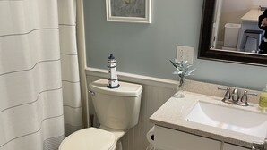 Ein Badezimmer mit Toilette, Waschbecken und einem gerahmten Bild an der Wand.