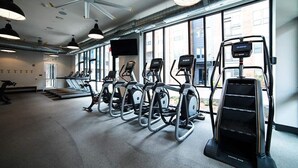 A gym with treadmills, elliptical machines, and a stair climber. - The Residences at CityWay (Indianapolis)