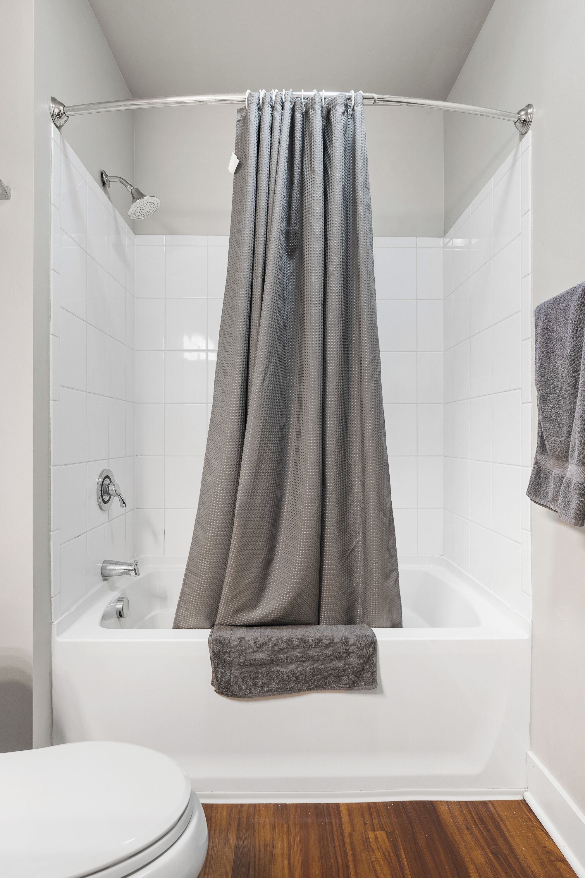 A modern bathroom with a bathtub, shower, and toilet.
