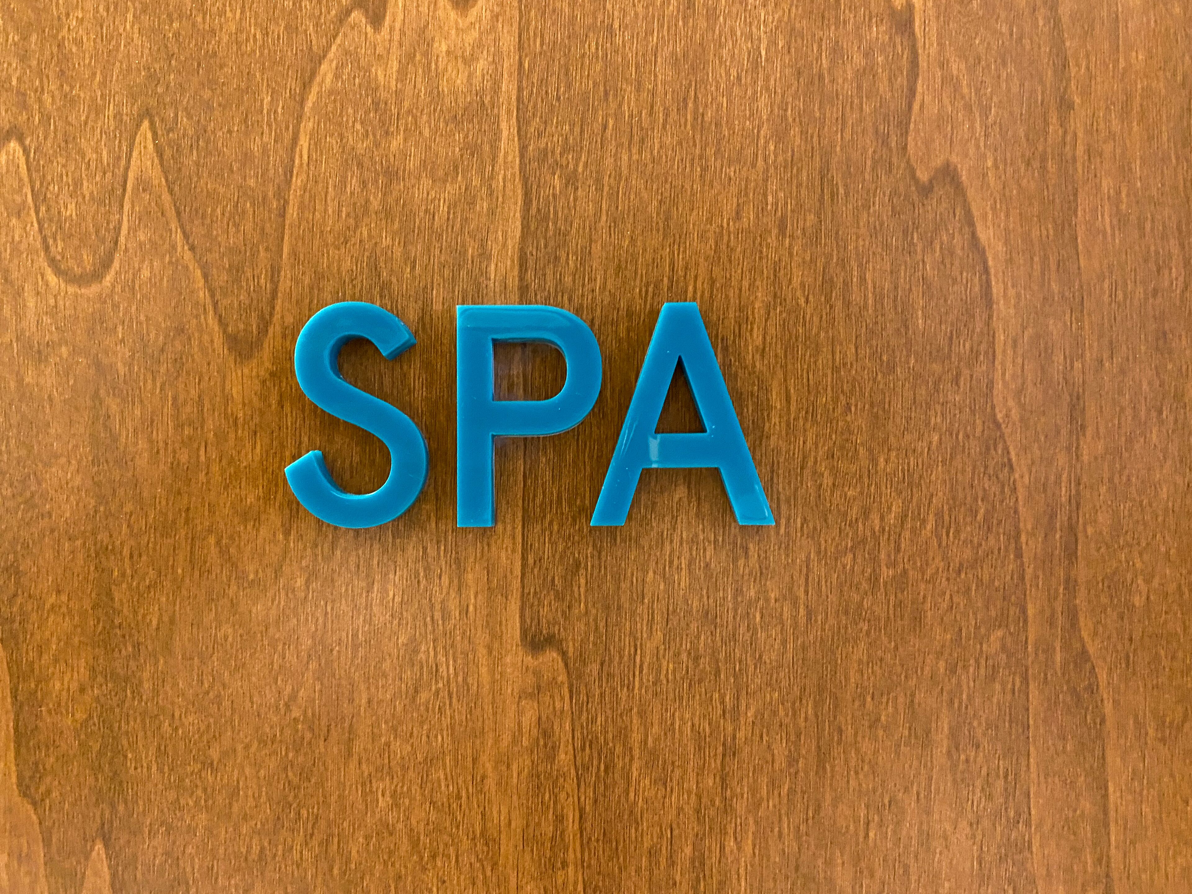The letters "SPA" in blue on a wooden background.