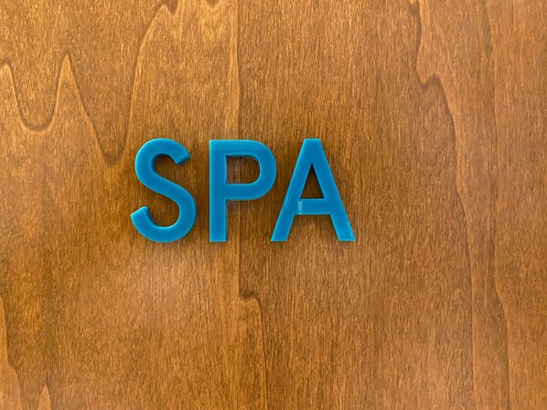 The letters "SPA" in blue on a wooden background.