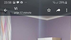 Une chambre à coucher avec un lit, deux chaises, une petite table et une armoire.