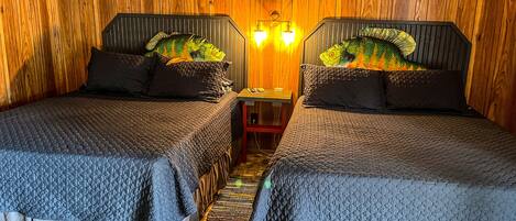 Une chambre avec deux lits, des murs en bois, une petite table avec une lampe et un panneau au-dessus des lits.