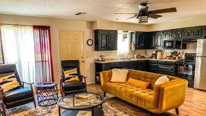 A living room with a sofa, armchairs, a coffee table, and a rug. - Reel Inn and Lodge (Quitman)