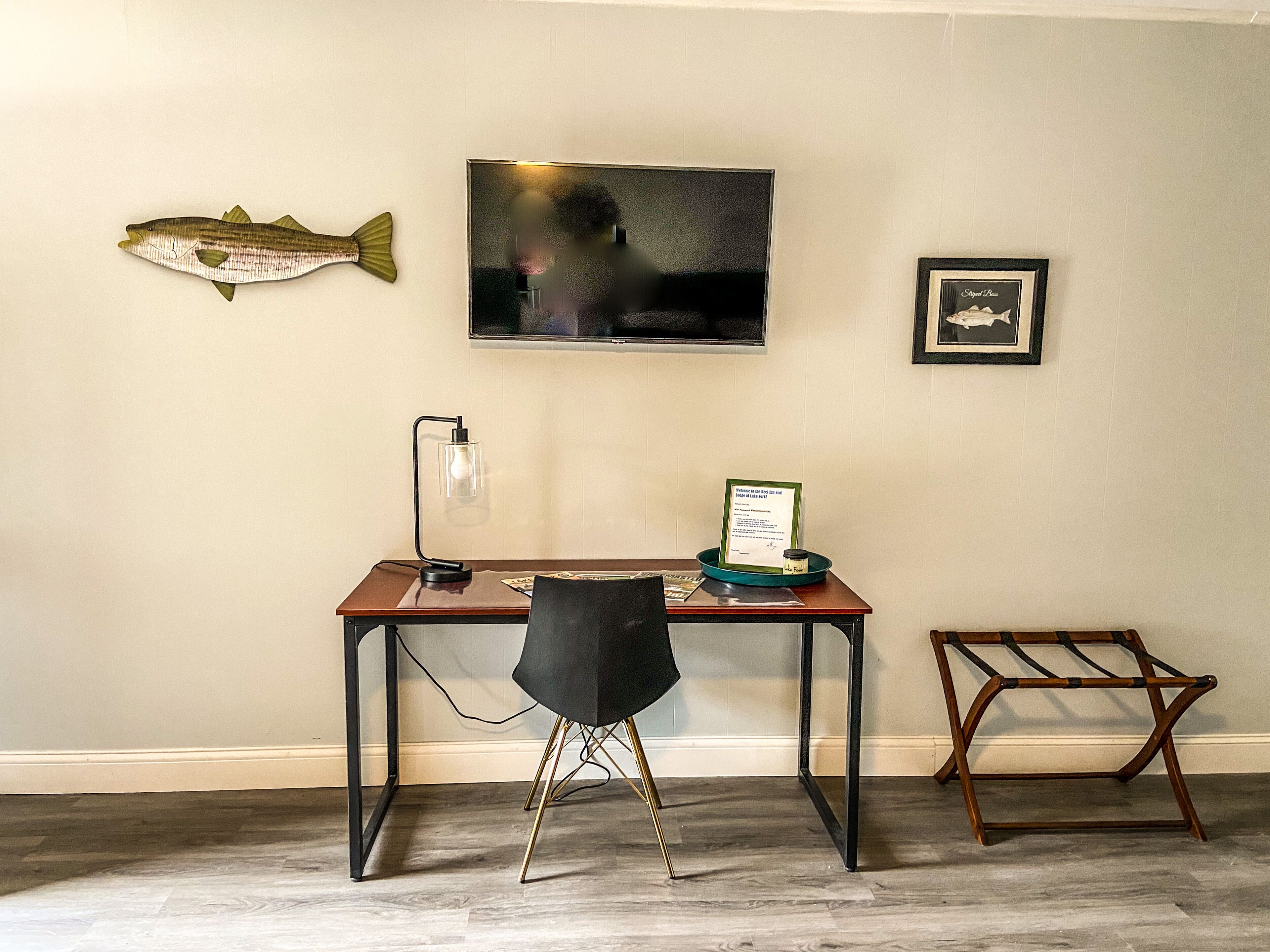 Une pièce comprenant un bureau, une chaise et un motif décoratif représentant un poisson sur le mur.