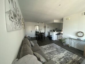 Relax in this stylish living space with a sofa, dining area, and kitchen, perfect for unwinding and enjoying quality time.