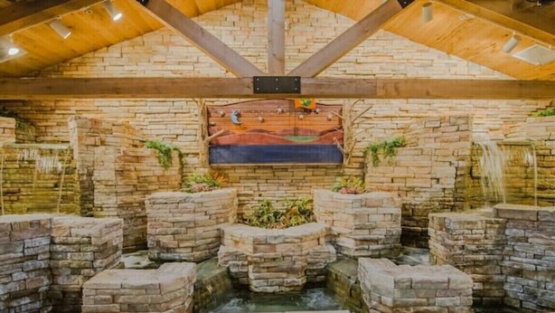 A stone-walled indoor pool with a wooden ceiling and a mural. - Lux 2BR Condo w/Jacuzzi, fast Wifi, Clubhouse, Gym (Branson)