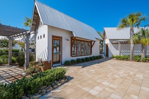 A modern building with a sloped metal roof, a covered entrance, and a paved driveway.