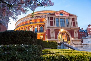 A historic building with a classical facade, large arched windows, and a central dome.
