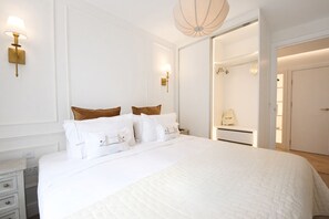 A hotel room with a large bed, a wardrobe, and a bathroom visible through an open door.