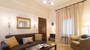 A living room with a brown sofa, a coffee table with a magazine, a lamp, a side table, and a chair. - Perfect Florence Location-Upscale Historic-AC-2 Bathrooms-Lift-Washer (Florence)