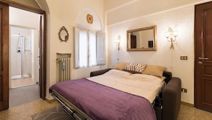 A bedroom with a bed, a shower, a radiator, and a door. - Perfect Florence Location-Upscale Historic-AC-2 Bathrooms-Lift-Washer (Florence)