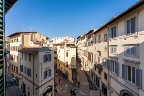 A narrow street flanked by buildings with shutters, a clear sky, and a few pedestrians. - Perfect Heart of Florence-Super Upscale Location-Roomy-Washer-Elevator (Florence)