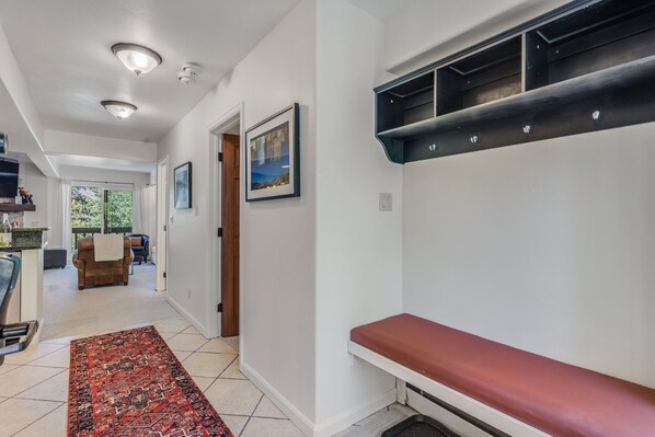 A hallway with a red bench, a patterned rug, and a framed picture on the wall. - 🏔️Ski-In, Ski-Out Condo~Hot Tub~Interlude 203🏔️ (Snowmass Village)