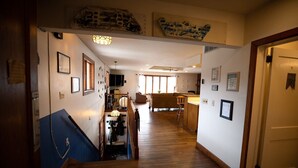 A hallway with a staircase, wooden flooring, and a dining area with a table and chairs.