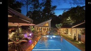 A residential property with a swimming pool, outdoor seating, and a covered patio area. - BARNDOMINIUM ONE OF A KIND!!! (Mandeville)