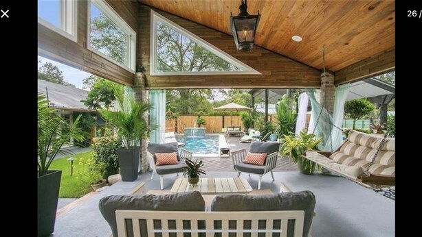 A covered outdoor area with a pool, seating, and potted plants. - BARNDOMINIUM ONE OF A KIND!!! (Mandeville)