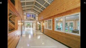 A wooden interior hallway with a high ceiling and large windows. - BARNDOMINIUM ONE OF A KIND!!! (Mandeville)