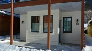 A white house with a porch, a black door, and a window with the number 1044. - The White House - Silverton Suite A Downstairs (Silverton)