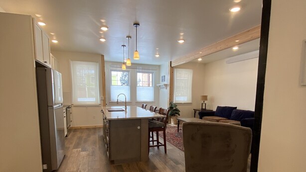 A spacious kitchen with a central island, wooden flooring, and pendant lighting. - The White House - Silverton Suite A Downstairs (Silverton)