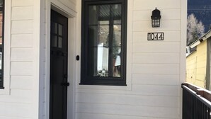 A white building with a black door and window, a black lantern, and the number 1044 on the wall. - The White House - Silverton Suite A Downstairs (Silverton)