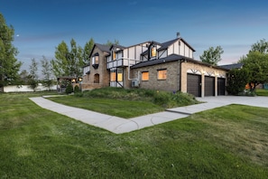 A two-story house with a brick facade, multiple windows, and a garage.