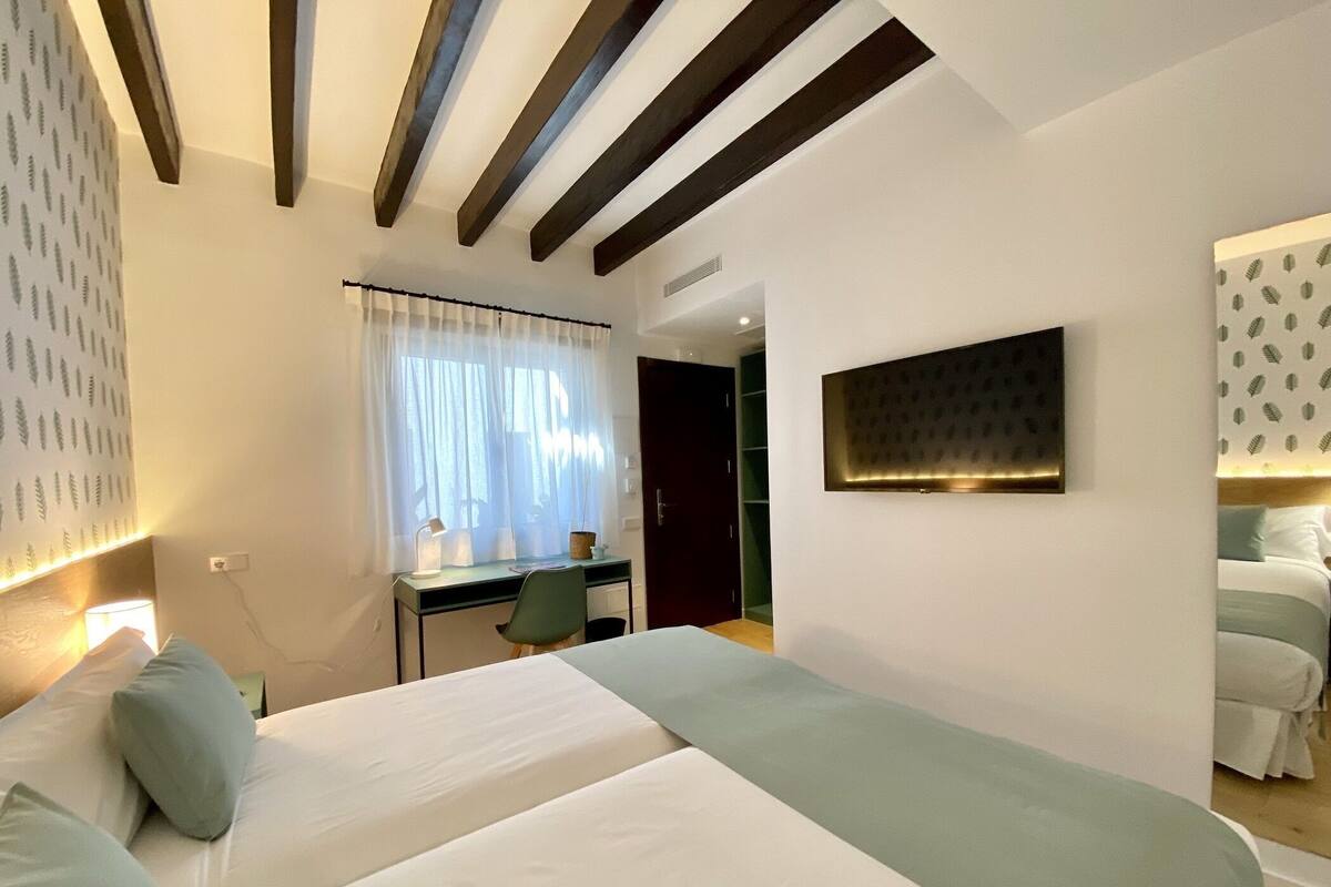 Quarto de hotel moderno com uma cama grande, uma escrivaninha e um guarda-roupa.