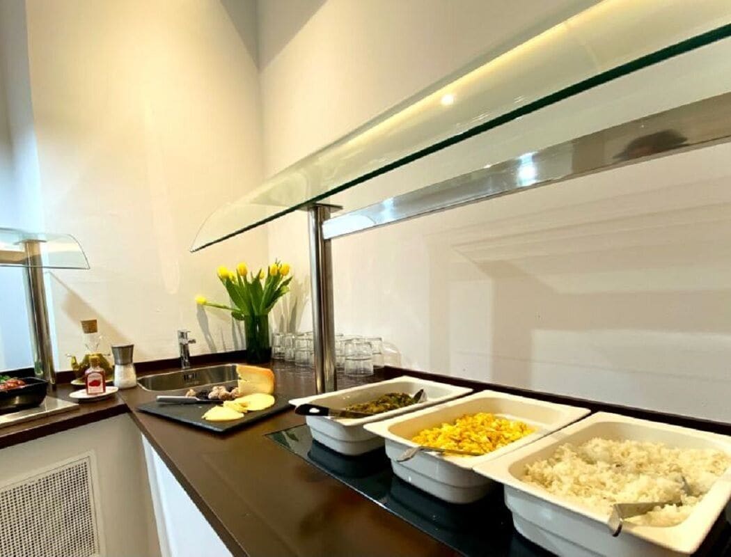 Un buffet proposant une variété de plats, notamment du riz, des légumes et un plat agrémenté d’une sauce jaune.