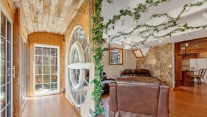 A spacious room with a large window, a leather sofa, and a welcome sign.